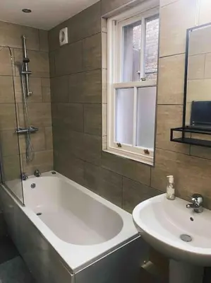 a bathroom with a bath tub and a sink at Lakes Loft in Cockermouth