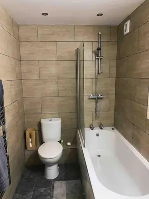 a bathroom with a toilet and a bath tub at Lakes Loft in Cockermouth