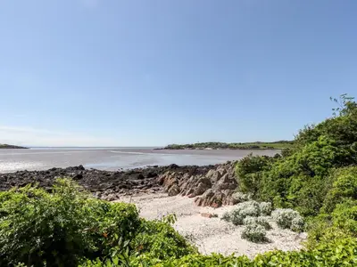 a path leading to a beach with a body of water at Seascape in Dalbeattie