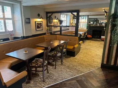 a restaurant with two tables and chairs in a room at The White Lion Inn in Penrith
