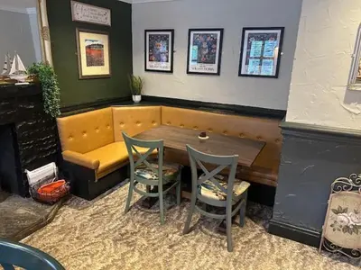 a table and two chairs and a bench in a room at The White Lion Inn in Penrith