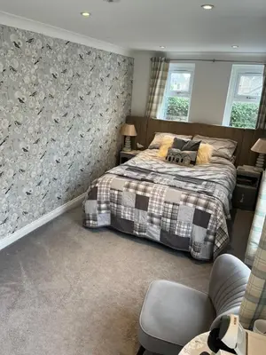 a bedroom with a bed with a plaid blanket at Beach room in Ayr