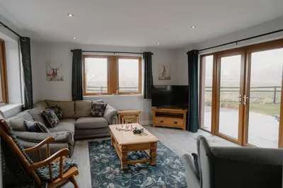 a living room with a couch and a table at Family friendly farmhouse with games and cinema room in Glencaple