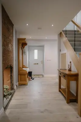 a hallway with a staircase and a stair case at Family friendly farmhouse with games and cinema room in Glencaple