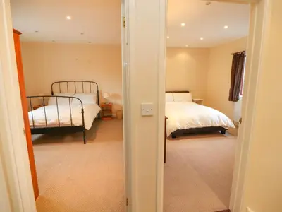 a bedroom with two beds and a door leading into a room at Valley View in Cleator Moor
