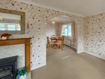 a dining room with a fireplace and a table at Tredegar in Newton Stewart