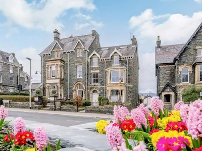 a large stone house with flowers in front of it at The Gables in Keswick
