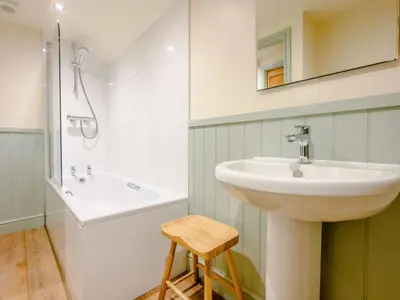 a bathroom with a sink and a mirror and a stool at The Gables in Keswick