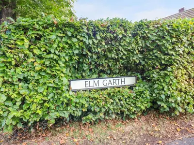 a sign that reads elm garden in front of a hedge at The Nest in Carlisle
