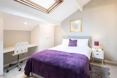a bedroom with a purple bed and a desk at Hampton Manor House - 9 Bedrooms in St Bees