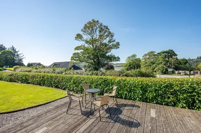 two chairs and a table on a wooden deck at Anthony House in Kippford