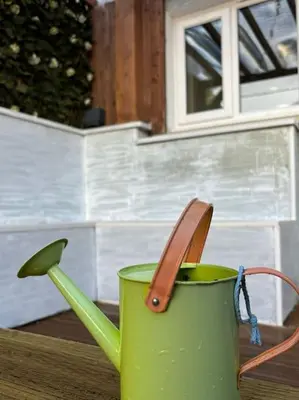 a green coffee cup with a spoon in it at Cosy Cumbrian home away from home in Whitehaven
