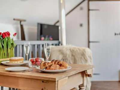a wooden table with two plates of bread and wine glasses at 1 Bed in Eskdale 95105 in Eskdale