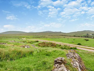 a field with green grass and a dirt road at 1 Bed in Eskdale 95105 in Eskdale