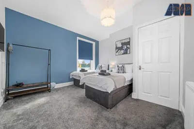 a bedroom with two beds and a blue wall at Carlisle 3Bed Sleeps 6 in Carlisle