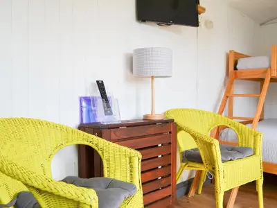 two yellow wicker chairs sitting next to a wooden dresser at Sian's Shepherds Hut - Uk43561 in Bowness-on-Solway