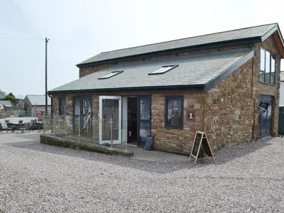 a small brick building with a sign in front of it at John Collingwood Bruce Suite - Uk43558 in Bowness-on-Solway