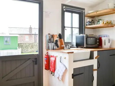 a small kitchen with a sink and a window at Hannah's Shepherds Hut - Uk43564 in Bowness-on-Solway