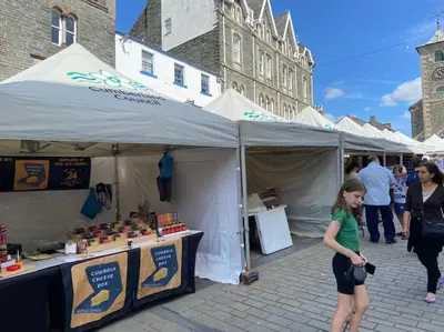 a young girl standing in front of a farmers market tent at Stanleys Sanctuary, Lake District in Plumbland