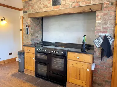 a kitchen with a stove and a brick wall at Beautiful 5BR House near Gretna Green with Garden - Pass the Keys in Kirkpatrick Durham