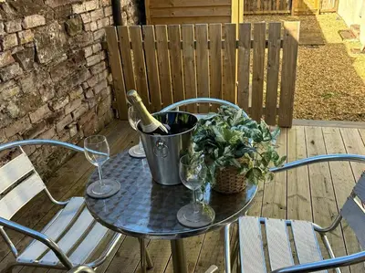 a table with a bottle of wine and two glasses at Harbour cottage Annan in Annan