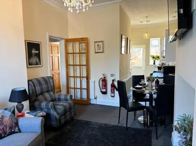 a living room with a couch a table and a chair at Quay cottage Annan in Annan