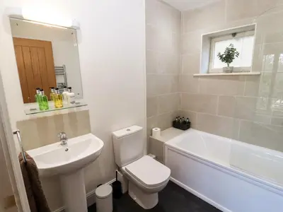 a bathroom with a toilet and a sink and a bath tub at Holborn Cottage, Blencathra Street in Keswick