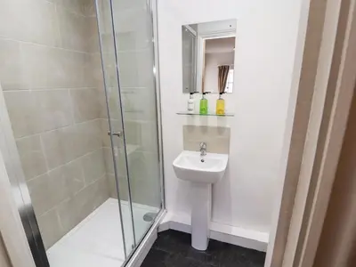 a bathroom with a shower and a sink at Holborn Cottage, Blencathra Street in Keswick
