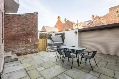 a patio with a table and chairs and a garage at Host & Stay - Chatsworth Townhouse I in Carlisle