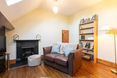 a living room with a leather chair and a fireplace at Host & Stay - Chatsworth Townhouse II in Carlisle