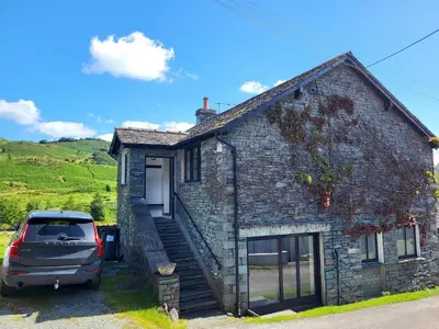 a car parked in front of a stone house at Wheelwrights House in Ambleside