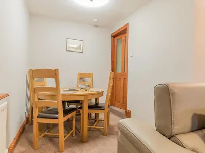 a dining room table with a chair and a couch at Stanwix Cottage in Carlisle