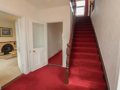 a red carpeted staircase in a home with a red carpet at Burnbank in Maryport