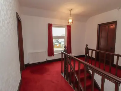a room with a red carpeted staircase and a window at Burnbank in Maryport