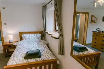 a bedroom with a bed and a mirror at Crookabeck B&B in Patterdale
