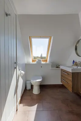 a bathroom with a toilet and a window at The Stables at Brickrow Farm in Ayr
