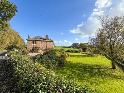 an old house in the middle of a green field at Kirkdale in Kirkton