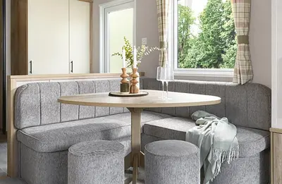 a living room with a table and stools at Queensberry Bay Essential Clover Caravan Pet in Annan