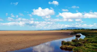 a beach with a river in the middle of it at Queensberry Bay Essential Clover Caravan Pet in Annan