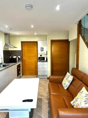 a living room with a couch and a kitchen at The Anne'x in Dalbeattie