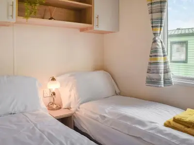 two beds in a small room with a window at Regal Lodge in Plumbland