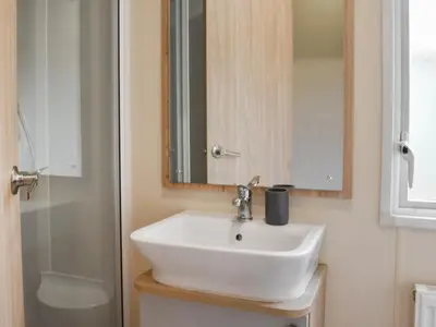 a bathroom with a sink and a mirror and a shower at Regal Lodge in Plumbland