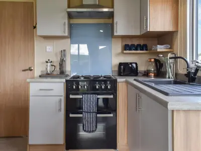 a kitchen with a stove and a sink at Regal Lodge in Plumbland