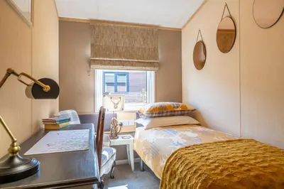 a bedroom with a bed and a desk and a window at Antler Lodge - Meadows Retreat Lodge Park in Plumbland