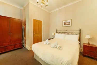 a bedroom with a large white bed with towels on it at Langdale Crag in Grasmere