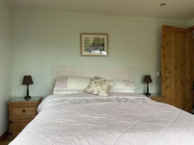 a bedroom with a large bed with two night stands at The Shack, Cally Avenue, Gatehouse of Fleet, Dumfries and Galloway, DG7 2 DH in Gatehouse of Fleet