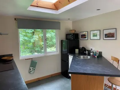 a kitchen with a black refrigerator and a sink at The Shack, Cally Avenue, Gatehouse of Fleet, Dumfries and Galloway, DG7 2 DH in Gatehouse of Fleet