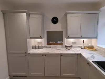 a kitchen with white cabinets and marble counter tops at Luxurious Georgian Town House in Langholm