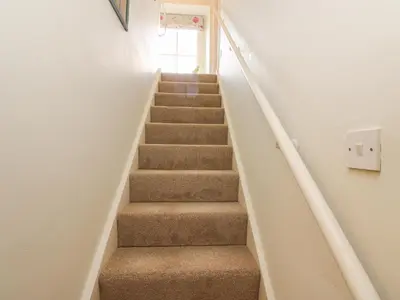 a staircase in a house with brown carpeted stairs at John Duftons Barn in Cockermouth