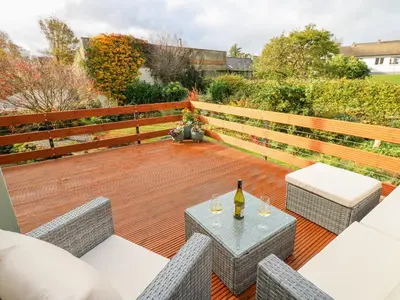 a patio with a table and a bottle of wine at John Duftons Barn in Cockermouth